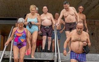Kontxan egunero bainatzen den erretiratu talde bat kabinetatik hondartzara jaisten.