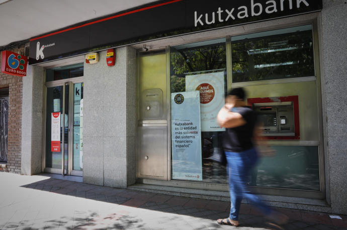 Una persona pasa por el exterior de la sucursal del banco Kutxabank.