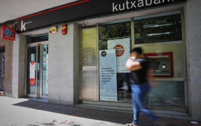 Una persona pasa por el exterior de la sucursal del banco Kutxabank.