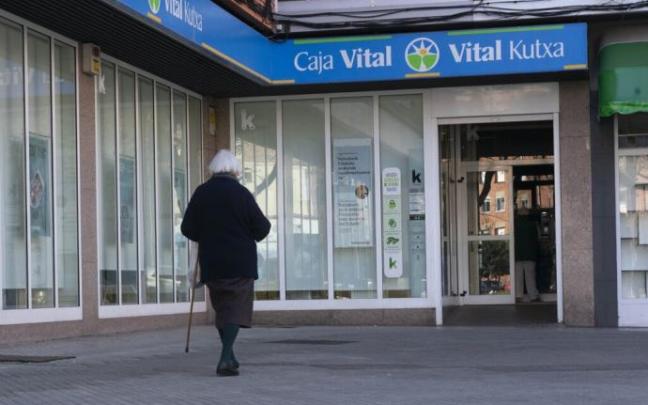 Una mujer se dirige a la oficina de Kutxabank en Reyes de Navarra