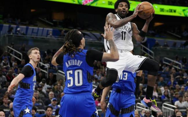 Kyrie Irving penetra a canasta ante Cole Anthony.