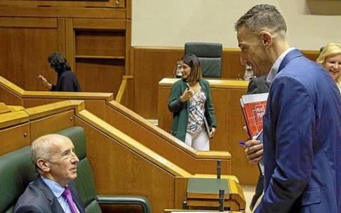 El vicelehendakari primero y consejero de Seguridad, Josu Erkoreka, conversa con el parlamentario del PSE Ekain Rico en el pleno del jueves. Foto: Efe