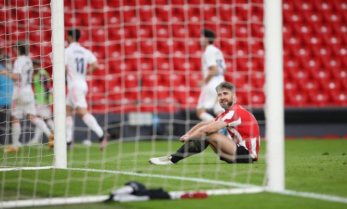 Yeray, cariacontecido sentado sobre el césped de San Mamés, mientras los jugadores del Madrid celebran el gol de Nacho.