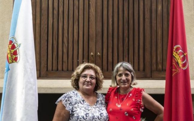 La presidenta y la vocal de cultura del Lar Gallego posan frente al horreo de la institución