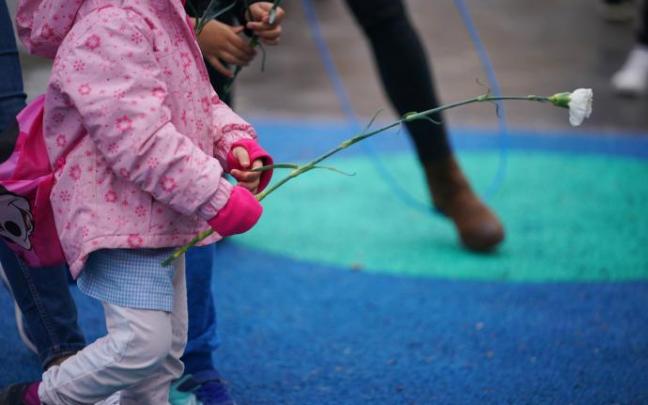 Un niño deposita flores en una concentración en el parque donde fue secuestrado un niño de 9 años.