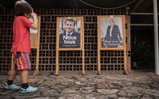Un niño pasea ante los carteles electorales en la embajada francesa en Kigali, Rwanda.