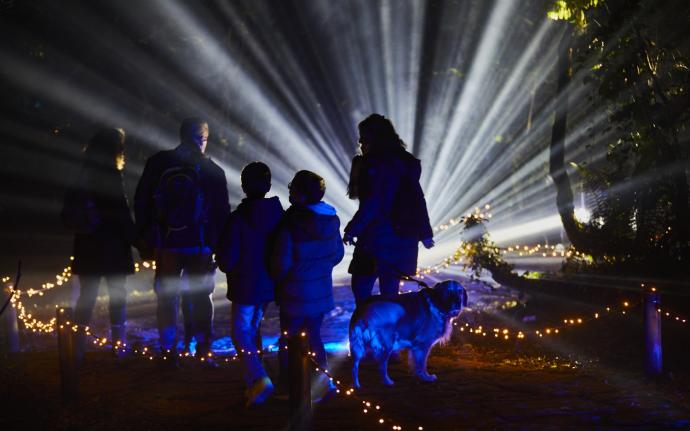 Una familia observa uno de los juegos de luces y sonidos del espectáculo programado en el parque de Pinosolo.