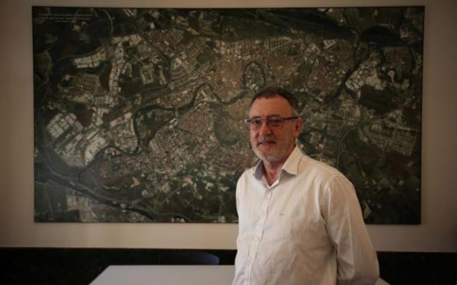 El portavoz de Geroa Bai en el Ayuntamiento de Pamplona, Patxi Leuza, delante de un mapa de la ciudad.