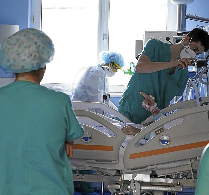 Varios sanitarios atienden a un paciente en una UCI. Foto: Pablo Viñas