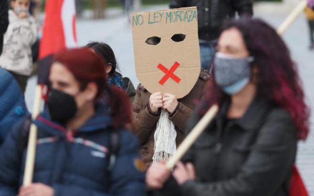 Una persona sostiene una careta donde se lee "No Ley Mordaza" durante una manifestación. Una persona sostiene una careta donde se lee "No Ley Mordaza" durante una manifestación.