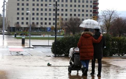 Una pareja joven camina con una silleta por una calle de Lezkairu. Una pareja joven camina con una silleta por una calle de Lezkairu.