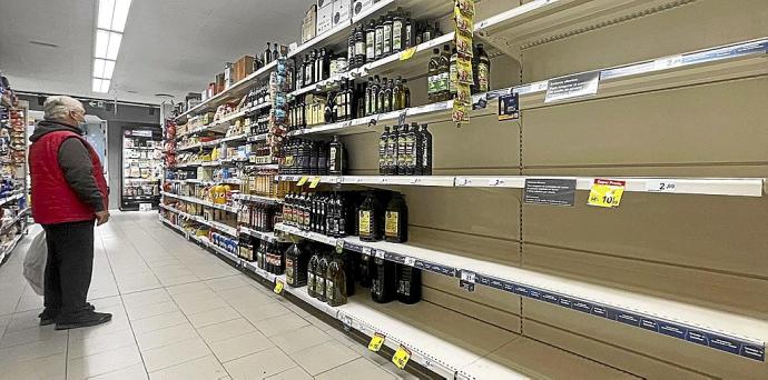 Un cliente observa la estantería de un supermercado desabastecida de aceite de girasol. Foto: Efe