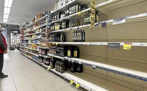 Un cliente observa la estantería de un supermercado desabastecida de aceite de girasol. Foto: Efe