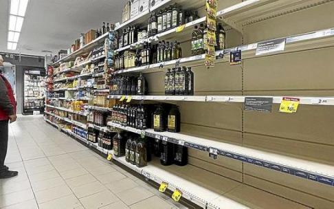 Un cliente observa la estantería de un supermercado desabastecida de aceite de girasol. Foto: Efe