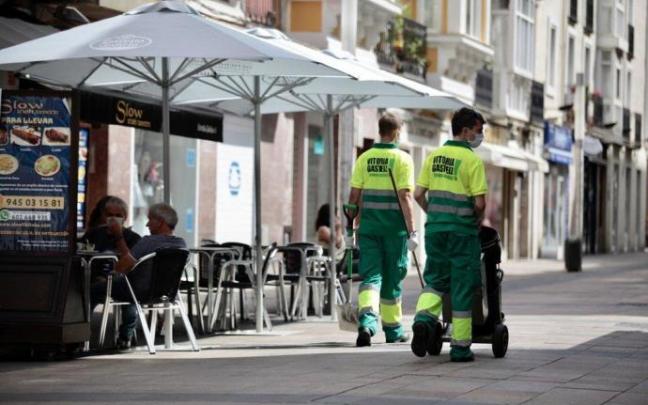 Dos operarios del servicio de limpieza por la calle Fueros.