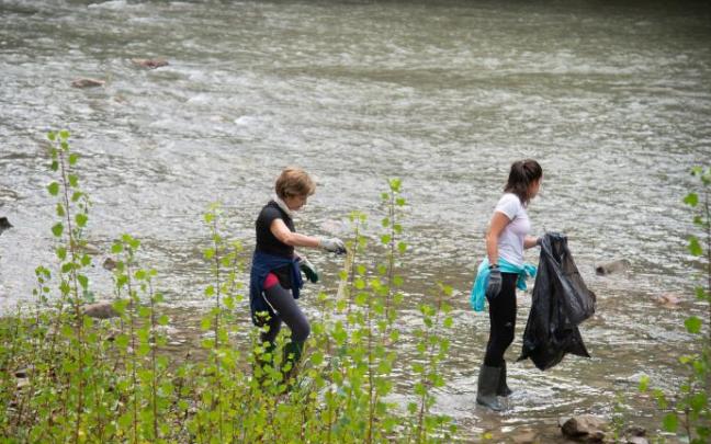 Unas voluntarias limpiando el entorno del río