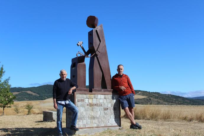 El artesano Félix Lizarraga y el alcalde del Valle de Lizoáin-Arriasgoiti flanquean la obra en el comunal de Lizoáin.