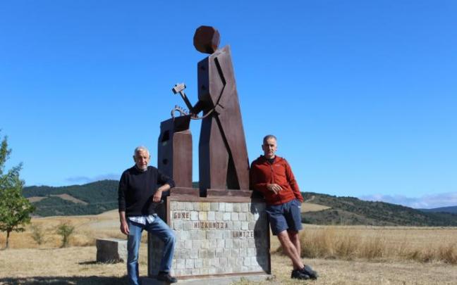 El artesano Félix Lizarraga y el alcalde del Valle de Lizoáin-Arriasgoiti flanquean la obra en el comunal de Lizoáin.