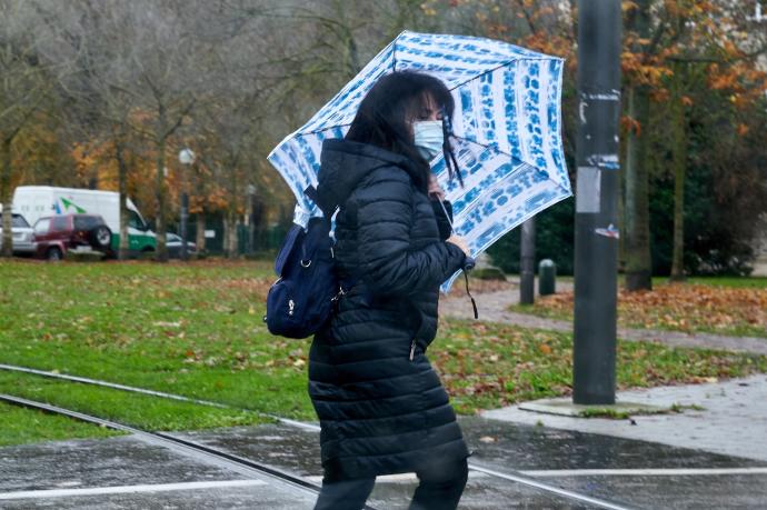 Una mujer camina bajo la lluvia.