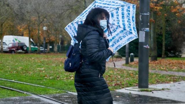 Una mujer camina bajo la lluvia.