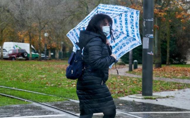 Una mujer camina bajo la lluvia.
