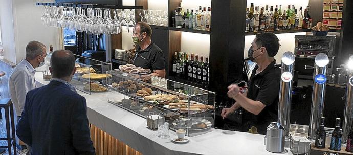 Dos camareros atendían ayer a varios clientes en la barra de una cafetería en Gasteiz. Foto: Alex Larretxi