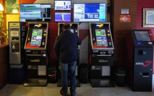 Un hombre apuesta en una máquina de un salón de juegos.