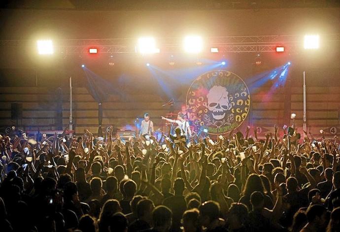 Cientos de personas bailando durante el concierto del grupo Dinamita.