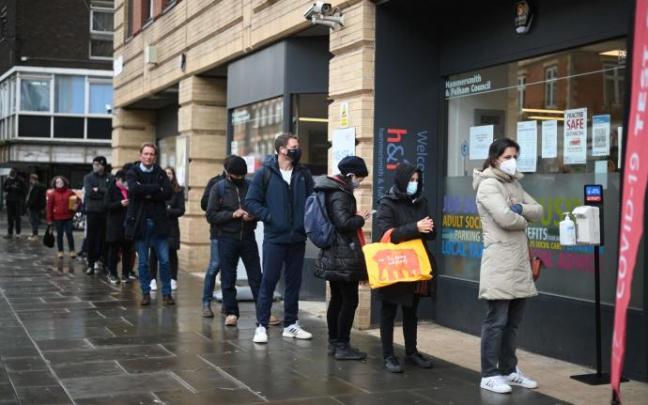 Personas haciendo cola en un centro de vacunación en Londres. Personas haciendo cola en un centro de vacunación en Londres.