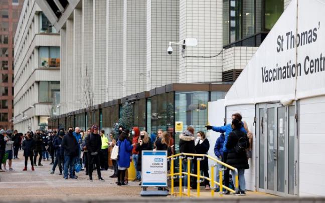 Personas haciendo cola ante un centro de vacunación en Londres