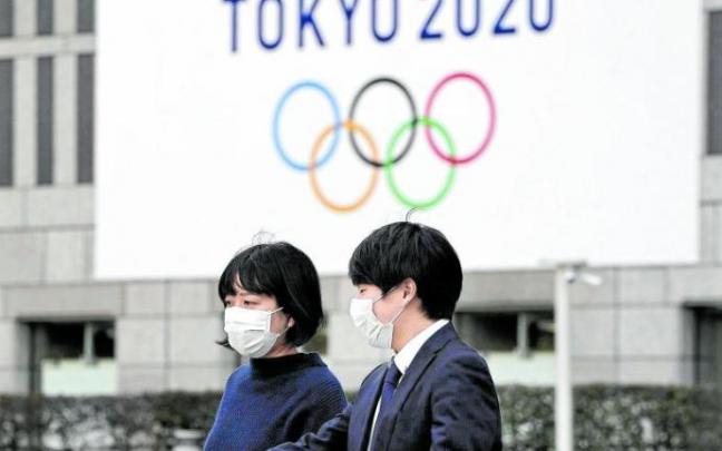 Dos personas pasan por delante de un logo de los Juegos Olímpicos de Tokio. Foto: Efe
