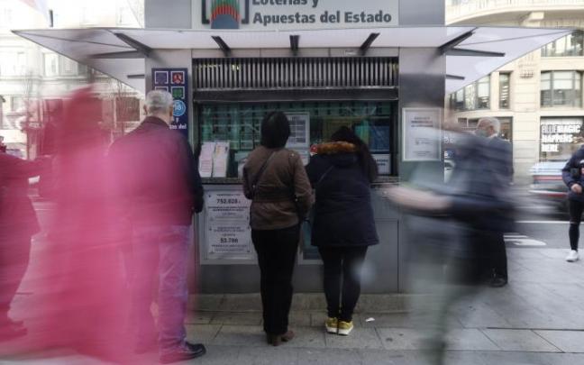 Personas haciendo cola ante una administración de lotería Personas haciendo cola ante una administración de lotería