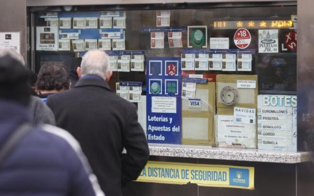 Varias personas, en una administración de lotería. Varias personas, en una administración de lotería.