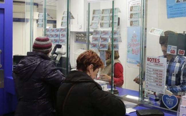 Varias personas compran Lotería del Niño en una administración. Varias personas compran Lotería del Niño en una administración.