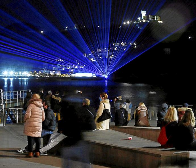 Tres momentos del espectáculo de luz que se ofreció ayer desde la isla.