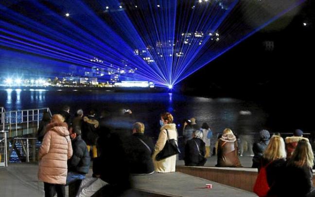 Tres momentos del espectáculo de luz que se ofreció ayer desde la isla.