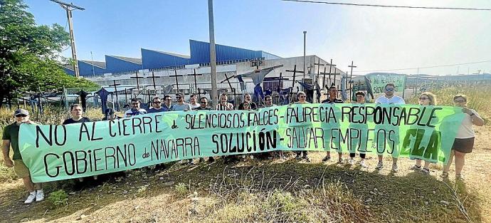 Empleados y empleadas de Silenciosos Falces posan con una pancarta reivindicativa a las puertas de la empresa.