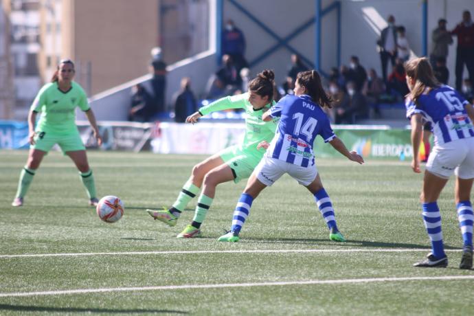 Lucía García trata de dar un pase ante la presión de una rival.