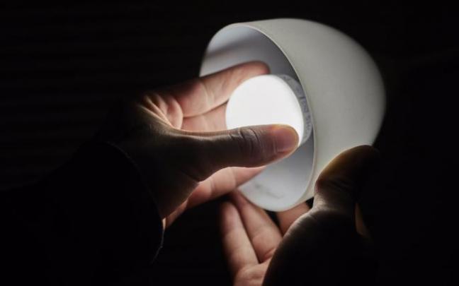 Un hombre cambia una bombilla.