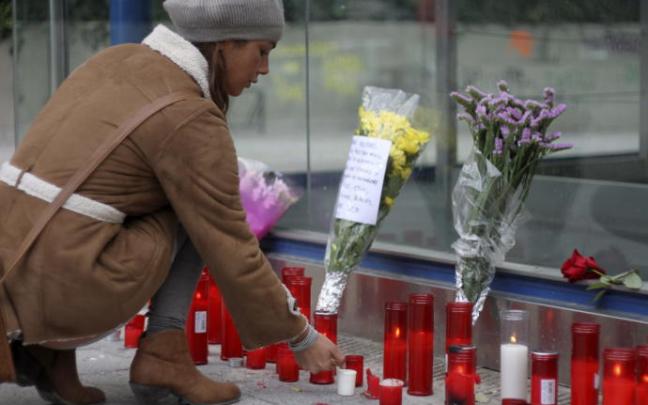 Una joven colocando velas y flores en la estación de metro de La Alameda de Osuna. Una joven colocando velas y flores en la estación de metro de La Alameda de Osuna.
