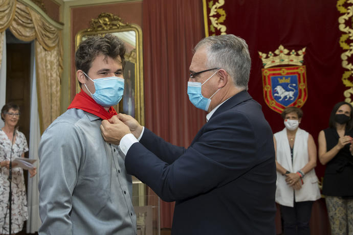 Magnus Carlsen recibe el pañuelo de San Fermín de manos del alcalde Maya.