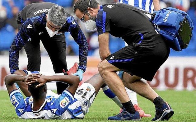 Isak, en el suelo, es atendido por el médico Javier Barrera y por el fisioterapeuta Imanol Soroa, en el partido del domingo. Foto: Ruben Plaza