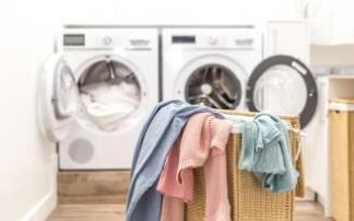 Cesto de la ropa sucia junto a una lavadora y una secadora.