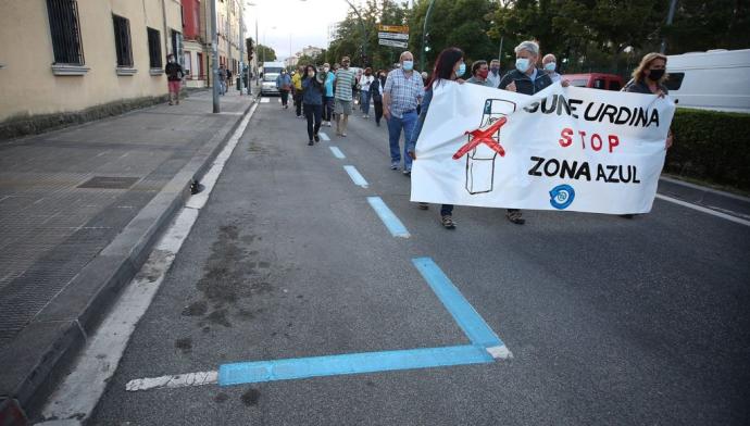 Imagen de la manifestación reciente a su paso por la avenida de Villava, con las plazas pintadas de azul.