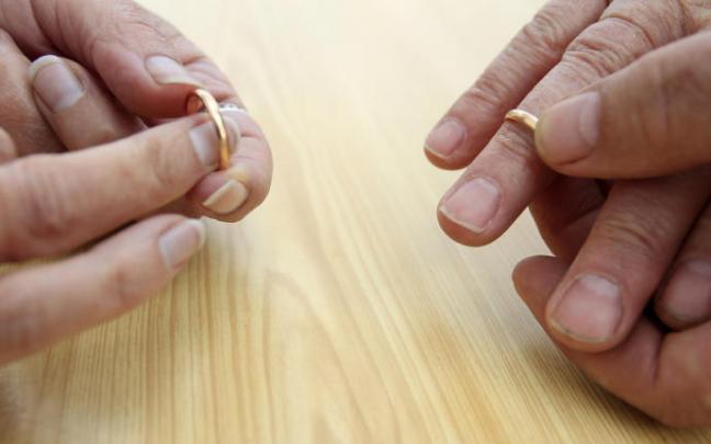 Manos de un matrimonio quitándose las alianzas para simbolizar su divorcio. Manos de un matrimonio quitándose las alianzas para simbolizar su divorcio.
