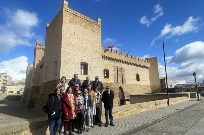 El colectivo de guías del castillo de Marcilla posa junto a la fortaleza que enseñan de forma altruista desde hace una década.