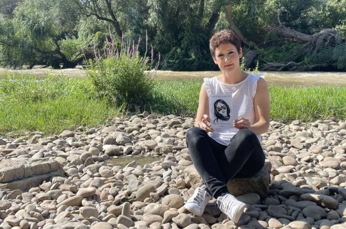 María Baigorri Lucea posa con su libro, 'Todos mis silencios', junto al puente y al río Ebro a su paso por Lodosa.