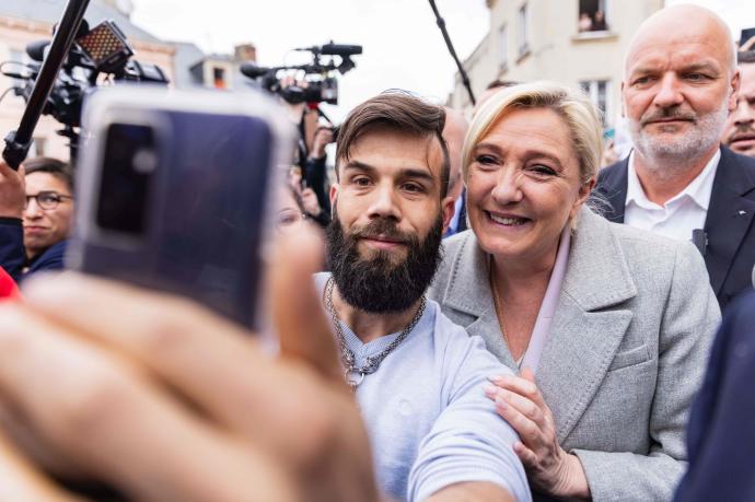 Le Pen posa para una foto con un seguidor durante una visita a Saint-Pierre-en-Auge.
