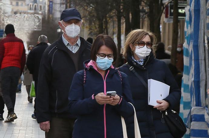 Varias personas pasean con la mascarilla.