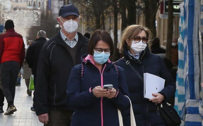 Varias personas pasean con la mascarilla.